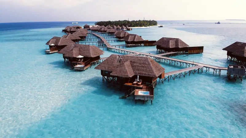 Overwater villas stretching into a turquoise Maldivian lagoon