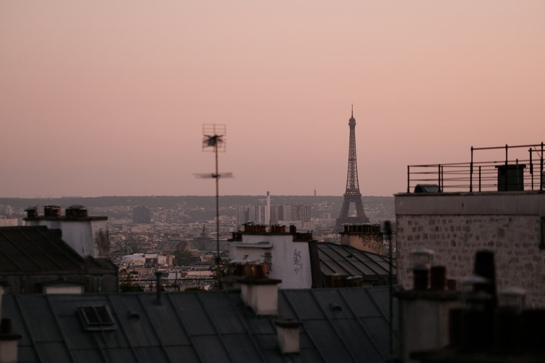 Paris rooftops at dusk with the Eiffel Tower on the skyline