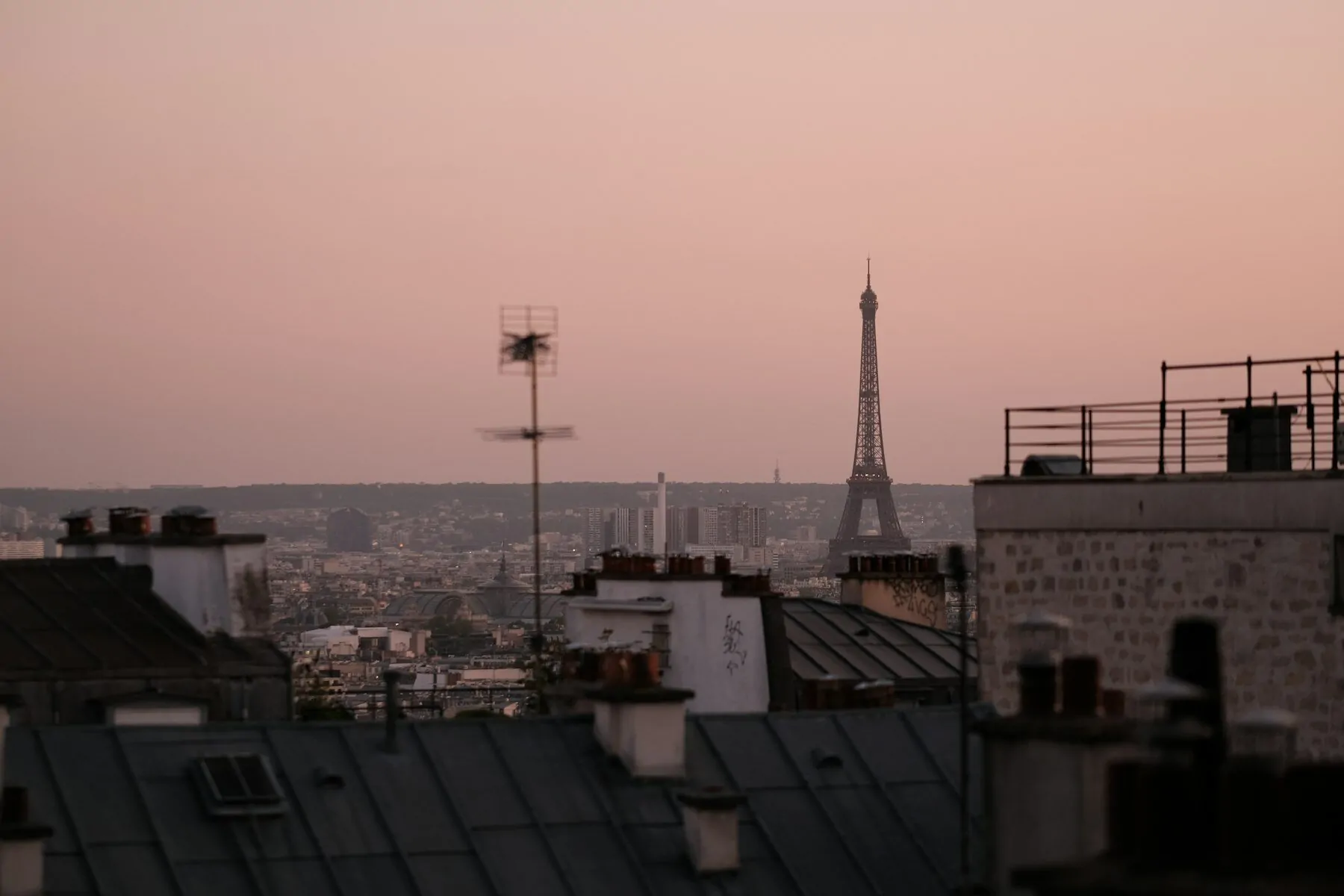 Paris rooftops at dusk with the Eiffel Tower on the skyline