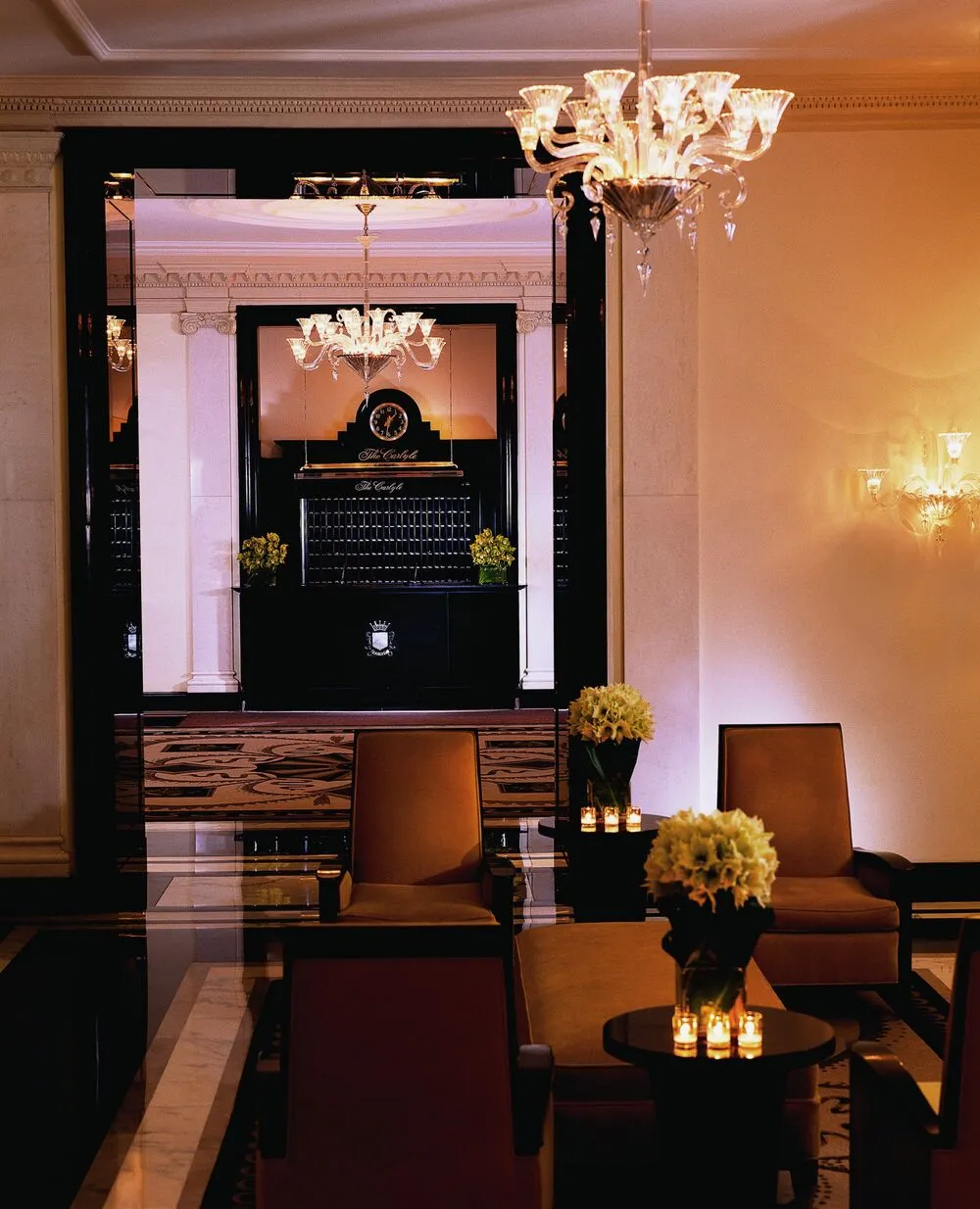 Chandeliers and lounge chairs in the lobby of a grand New York hotel